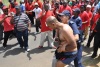 Police escort a man wearing an anti-NUM t-shirt. The man had marched into the NUM group and was attacked. Police came to his rescue..