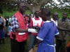 KRCS deputy Secretary General, Emmanuel Owako distributing shoes to pupils at Fortenan primary school after treating over 600 people against jiggers infestation (Oduor Omondi, News24 user)