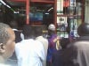 Kenyans cluster in the door way of an electronic shop to follow the election results on a television.
