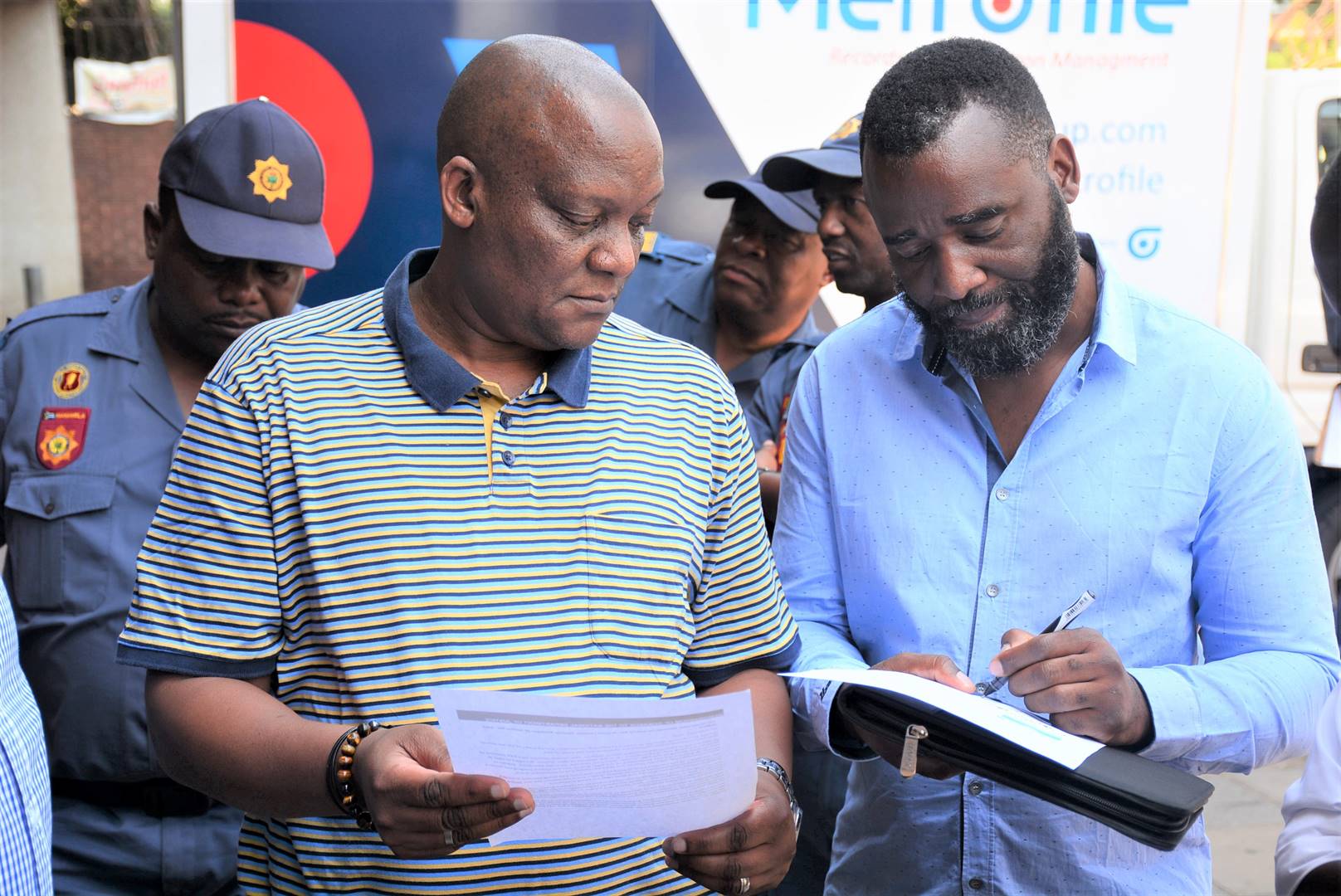 Castro Musinyai (Right) convener of march against parental Alienation Syndrome and child abuse hand over the memorandum of demands to Musa Mbongwe (Left-T-shirt) from the office of the Deputy Minister of Justice and Constitutional Development. Photo by Raymond Morare