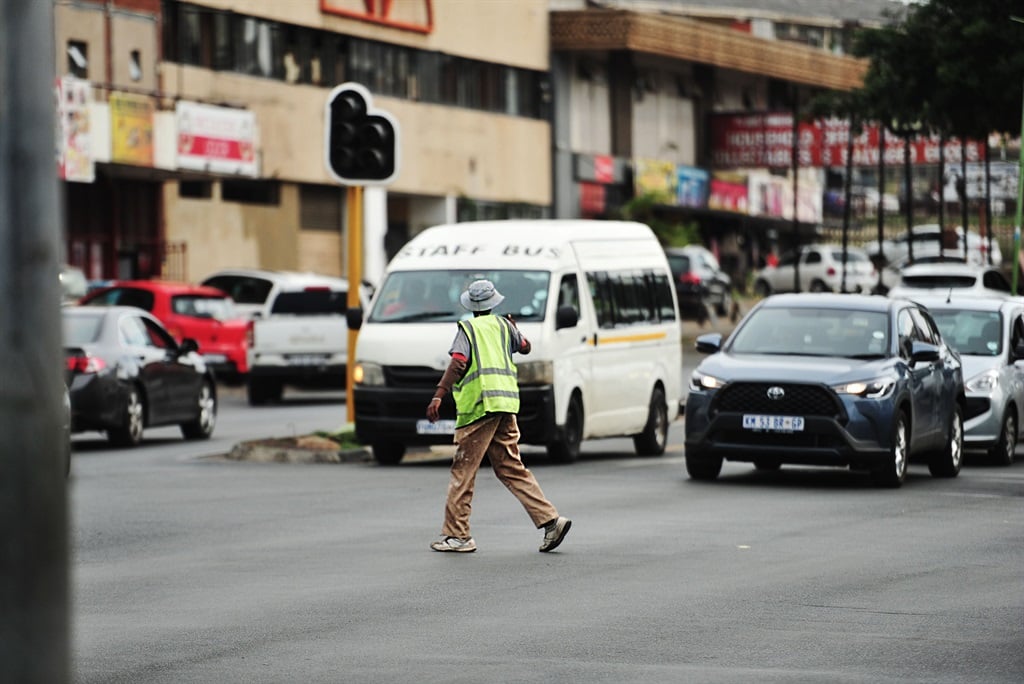 Homeless  people direct traffic when the traffic lights go off during load shedding. 