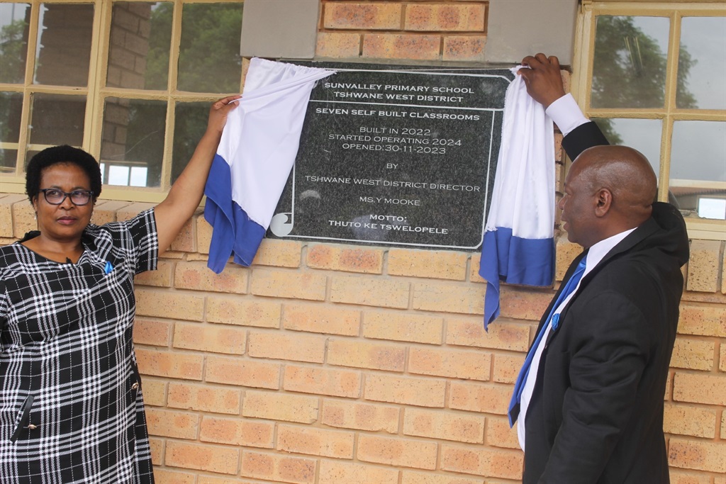 Director Yvonne Mooke from Tshwane West District and Principal Samuel Mashiane cut the ribbon to unveil the new classrooms. Photo by Thokozile Mnguni
