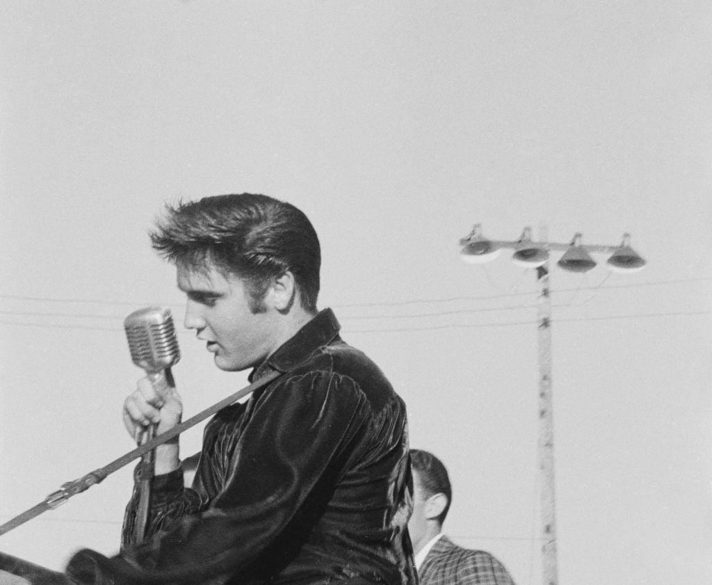 American singer and actor Elvis Presley (1935-1977) speaking into a microphone at the Mississippi-Alabama Fair & Dairy Show in Tupelo, Mississippi, 26 September 1956. 