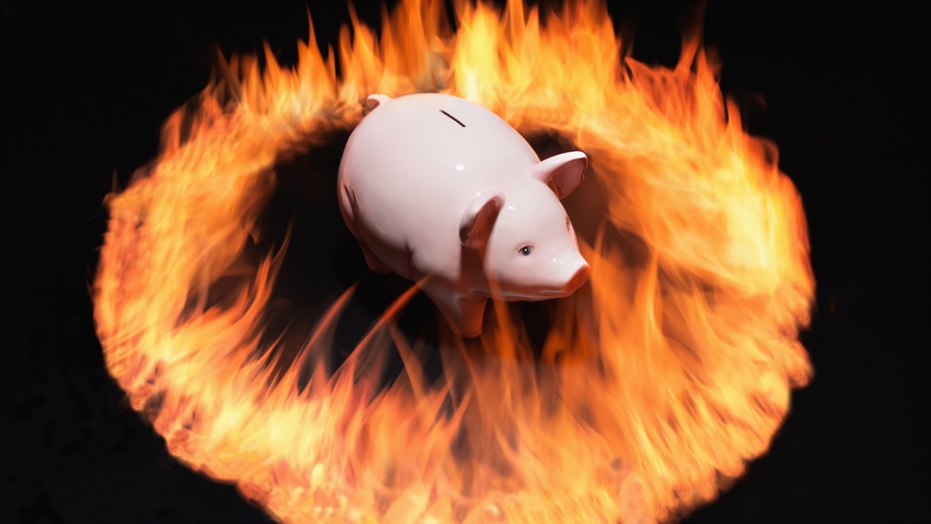 Piggy bank surrounded by ring of flames