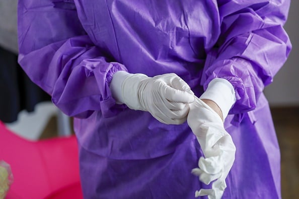 A doctor puts on surgical gloves before carrying out coronavirus testing on a patients at a drive-in clinic at the hospital in Gross Gerau, Germany, on Monday, March 9, 2020. German ChancellorÂ Angela Merkels government will invest an additional 12.4 billion euros ($14.1 billion) between 2021 and 2024 and take its first steps to help companies and workers affected by the fallout from the coronavirus outbreak. Photographer: Alex Kraus/Bloomberg via Getty Images