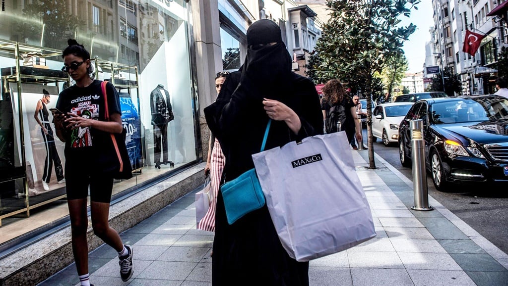 A woman wearing a niqab and headscarf, with other shoppers in Istanbul, August 13, 2018. YASIN AKGUL/AFP via Getty Images
