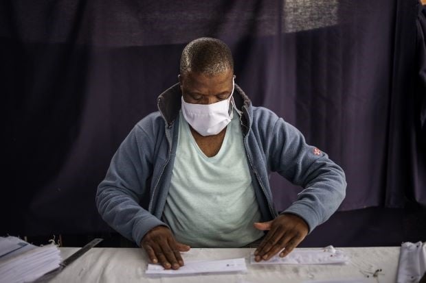 A man stitches cotton fabric pieces used to manufacture reusable face masks in Johannesburg's Alexandra township. (Michele Spatari / AFP)
