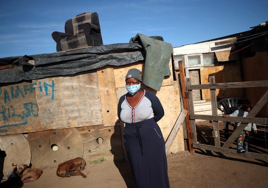 A community volunteer waits beneath a shack as she prepares to distribute food packages during the nationwide lockdown aimed at limiting the spread of the Covid-19 coronavirus in a township in Cape Town. Picture: Mike Hutchings/Reuters