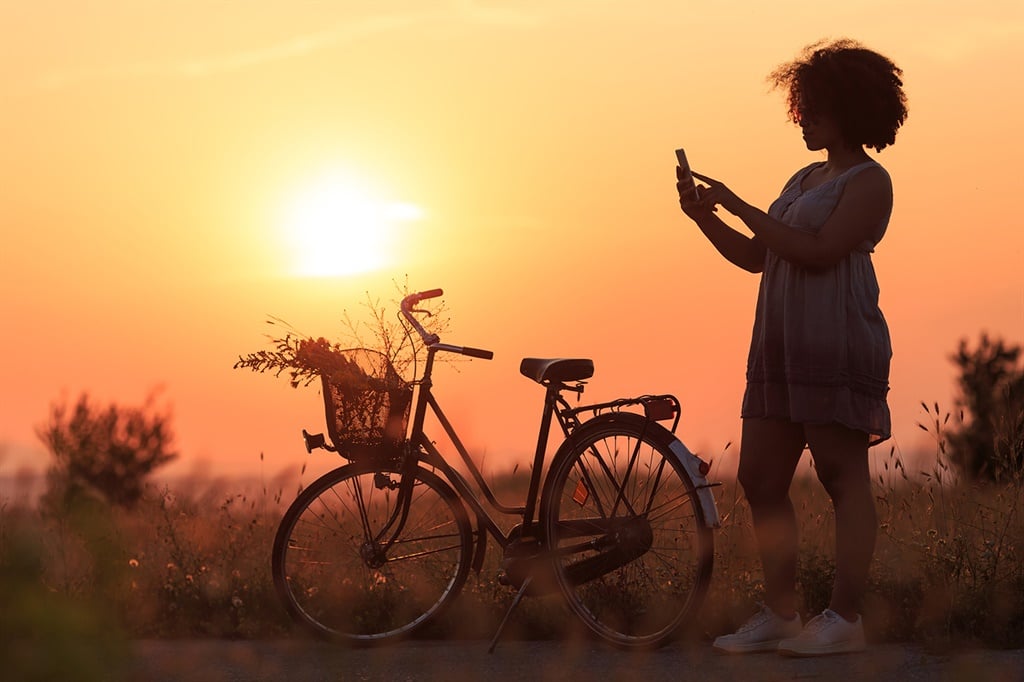 Silhouette of beautiful african woman with bike us
