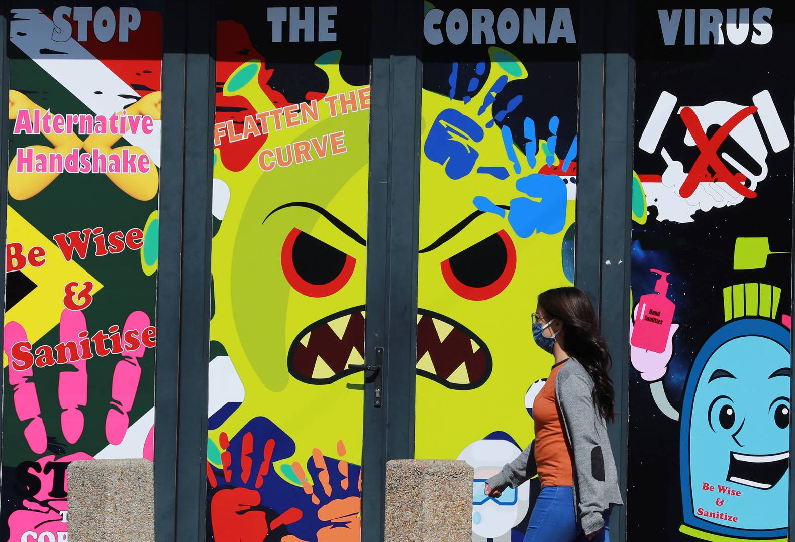 A woman wearing a face mask to prevent the spread of the Covid-19 walks past a mural in Cape Town during the third week of lockdown to contain the spread of the pandemic. Picture: Nardus Engelbrecht/AP Photo