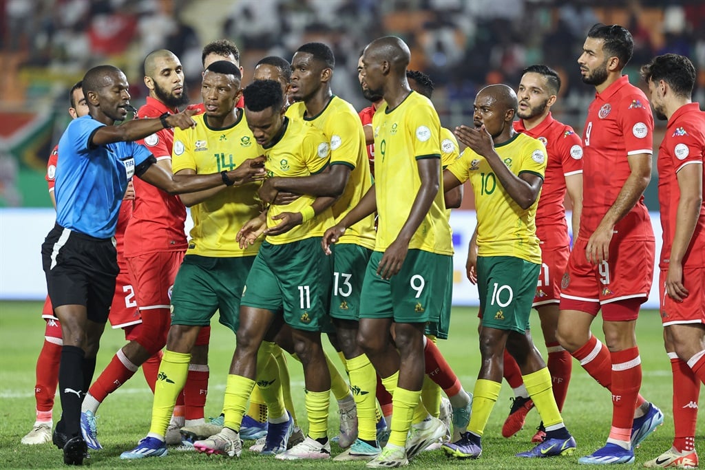 South Africa's forward #11 Themba Zwane reacts as Senegalese referee Issa Sy (L) gestures while talking to players during the Africa Cup of Nations (CAN) 2024 group E football match between South Africa and Tunisia at the Amadou Gon Coulibaly Stadium in Korhogo on 24 January 2024.  