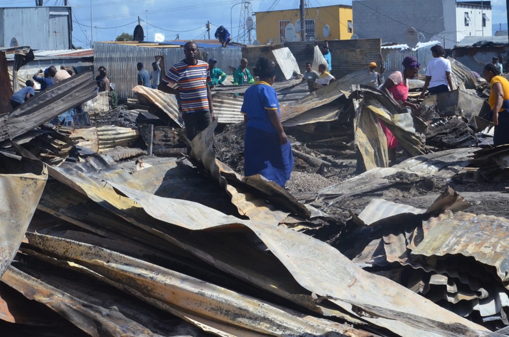 Residents of School Site squatter camp picking up pieces after their shelters were destroyed. Photo by Lulekwa Mbadamane
