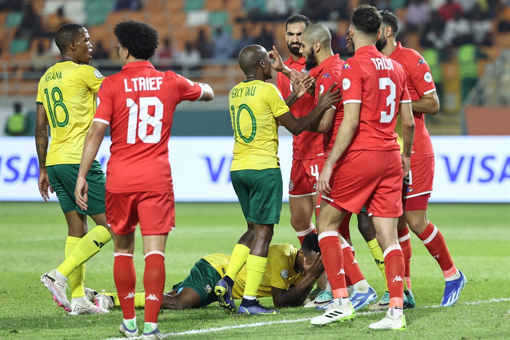 South Africa's forward #10 Percy Tau argues with Tunisia's midfielder #14 Aissa Laidouni (3rd R) as South Africa's forward #11 Themba Zwane (down) reacts during the Africa Cup of Nations (CAN) 2024 group E football match between South Africa and Tunisia at the Amadou Gon Coulibaly Stadium in Korhogo on January 24, 2024.
