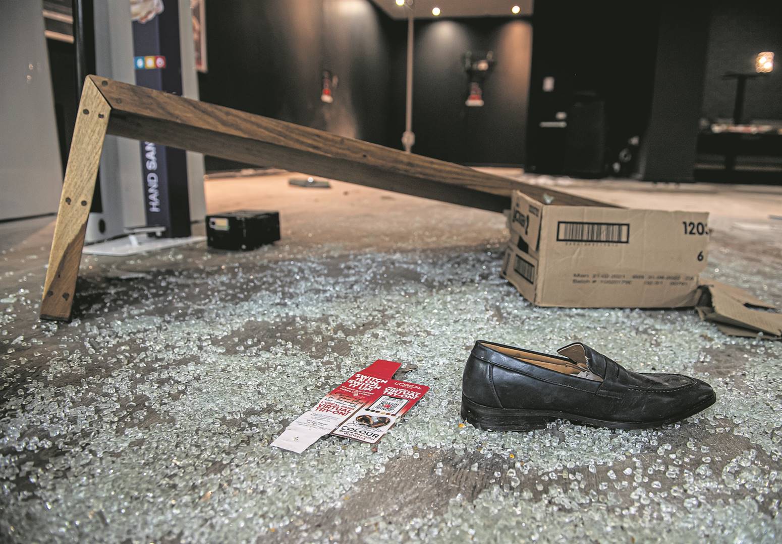 Gebreekte glas en ’n skoen lê op die vloer van ’n geplunderde winkel in Empangeni. Foto: Deon Raath