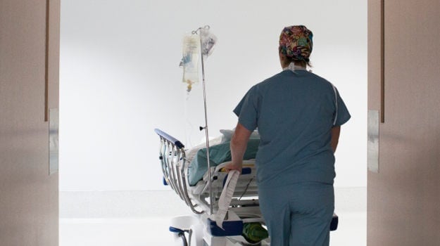 A nurse pushes a patient into surgery.