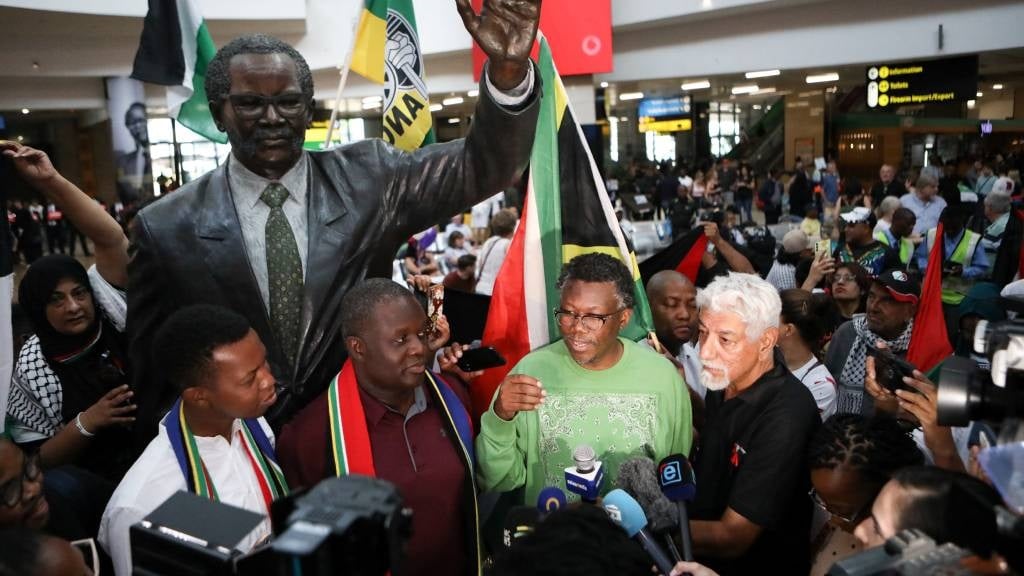 Advocate Tembeka Ngcukaitobi (Centre), a member of the South African legal team, talks to journalists after landing back in South Africa after representing the country in a two-day hearing against Israel at the International Court of Justice (ICJ), at the OR Tambo International Airport in Ekurhuleni.