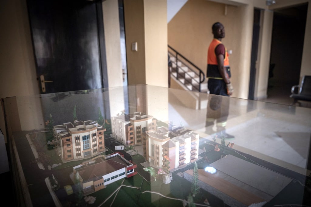 A worker next to a model of the Hope Hostel, which was getting ready to welcome migrants from United Kingdom in Kigali, Rwanda, in May 2022. The hostel previously housed genocide orphans. (Photo by Simon WOHLFAHRT / AFP)
