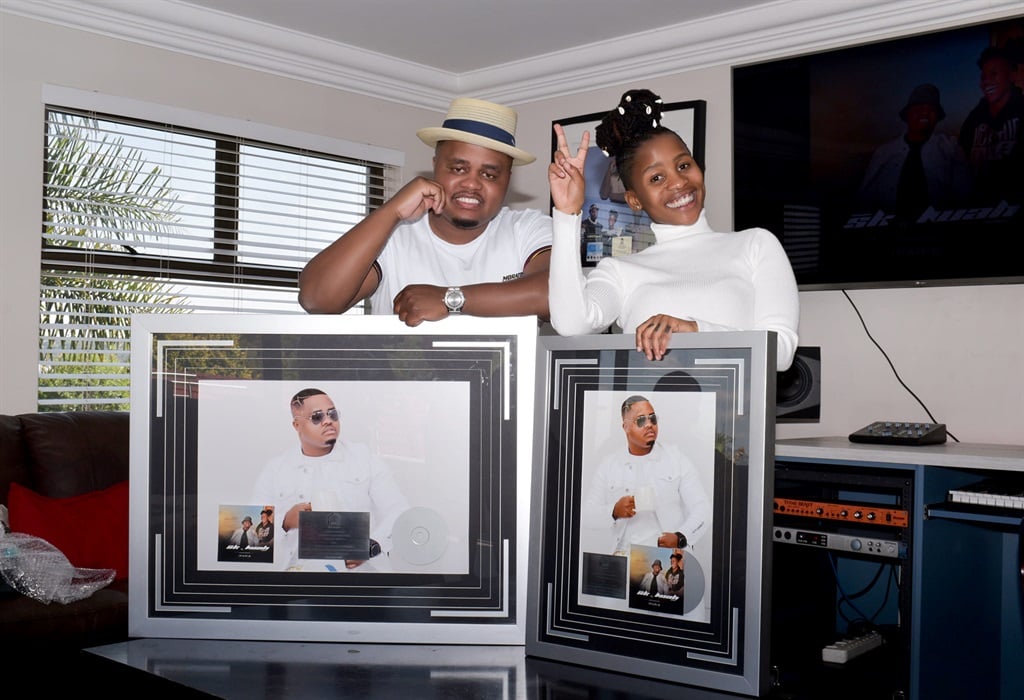 Musician Mthandeni with Lwah Ndlunkulu holding  their Platinum plaques. 