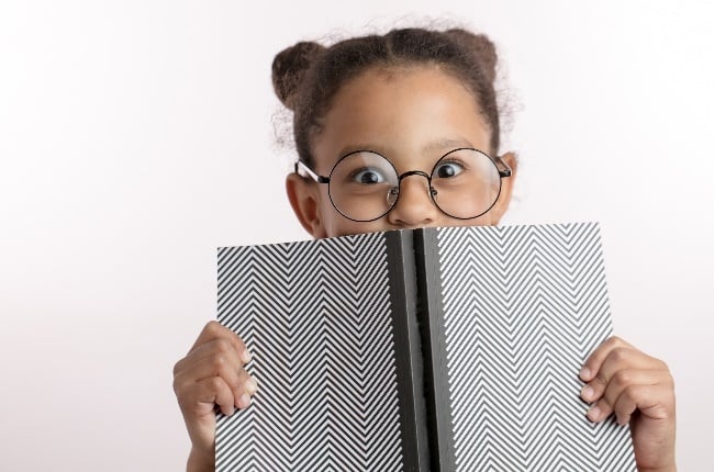 Kid hiding behind a book. (Photo: Getty Images) 