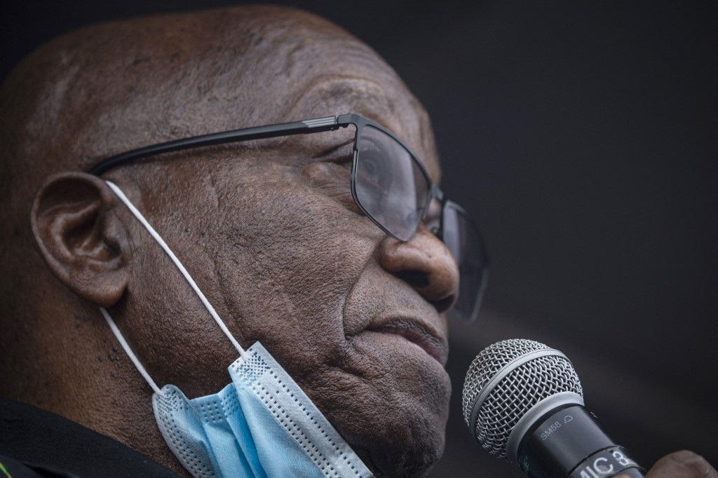 Unmasked: Former president Jacob Zuma addresses his supporters in front of his Nkandla compound on Sunday.