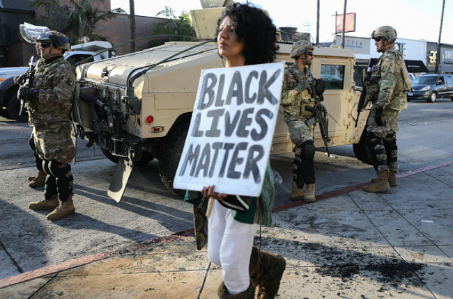 A woman carries a 'Black Lives Matter' sign