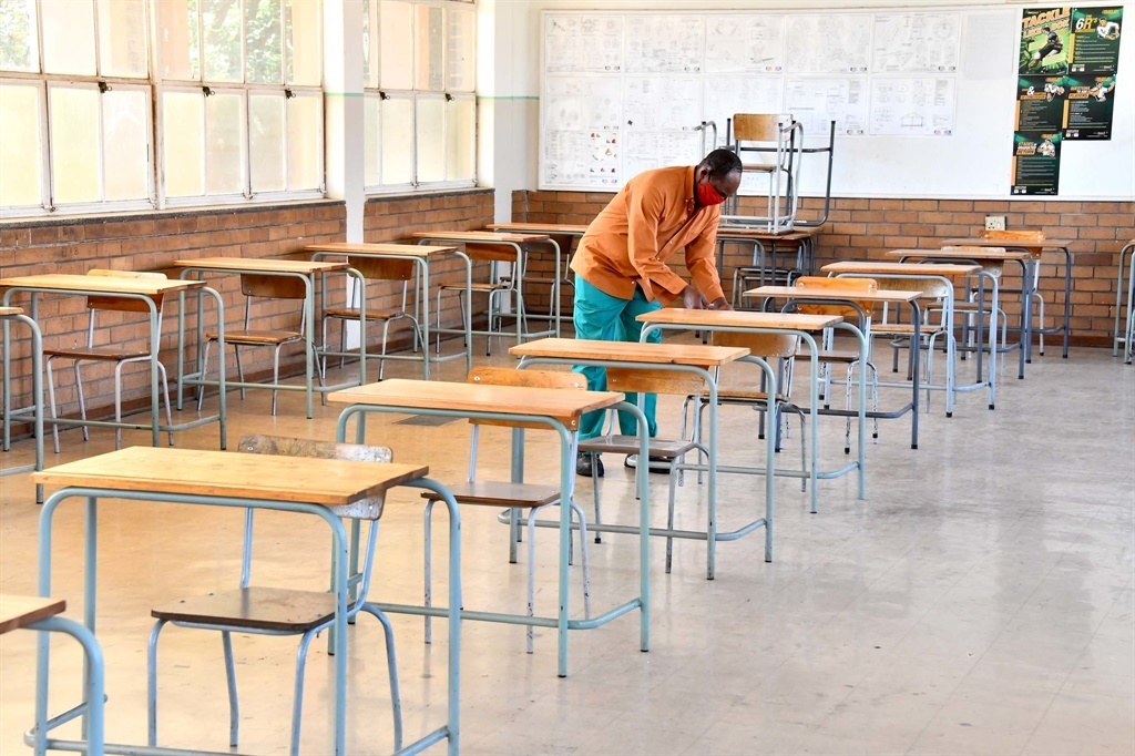 A worker cleaning a classroom.