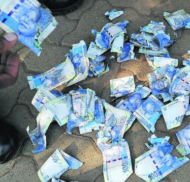 A man was bust with bank notes in Diepkloof, Soweto, shortly after a cash heist in Krugersdorp.         Photo by Trevor Kunene