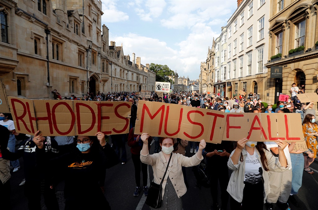 Demonstrators hold placards during a protest arranged by the 'Rhodes Must Fall' campaign, calling for the removal of a statue of British businessman and imperialist Cecil John Rhodes, from outside Oriel College at the University of Oxford in Oxford, west of London.