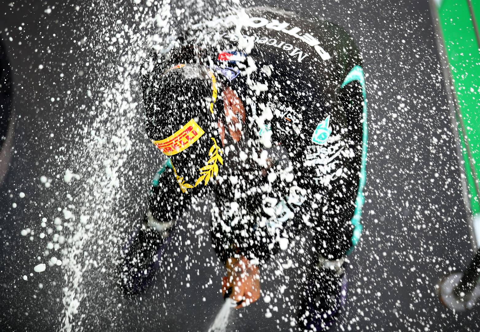 Lewis Hamilton loop onder die vonkelwyn deur nadat hy Sondag in Barcelona die Spaanse Formule Een-Grand Prix gewen het.  Foto: AP