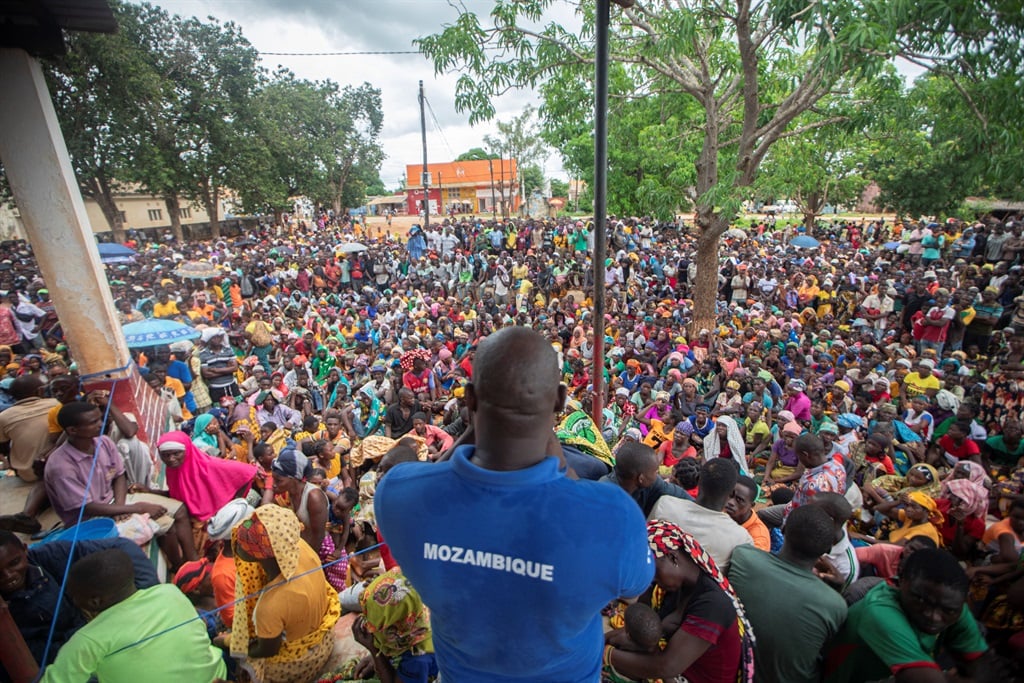 A staff member of the World Food Program addresses displaced people from the province of Cabo Delgado gathering to received humanitarian aid in the town of Namapa, Mozambique on 27 February 2024 following an outbreak of violence. 
