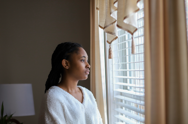 Woman looking out window (PHOTO: Getty Images)