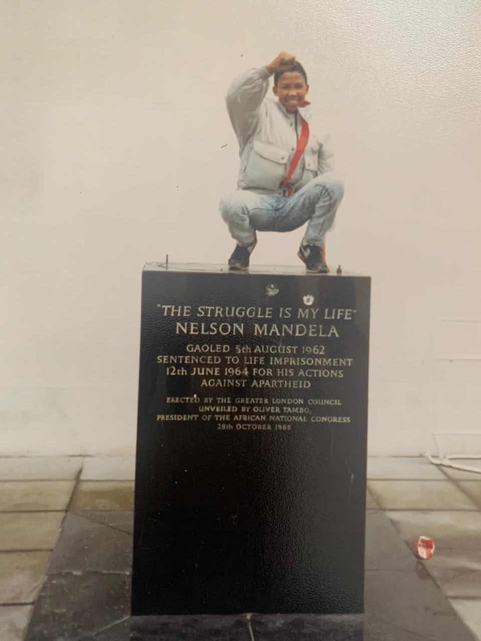 A young Mandla Mandela stands atop a plinth which 