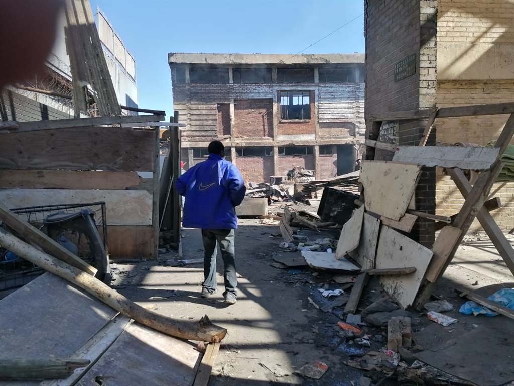 A man looks on at his house which was burned in a 