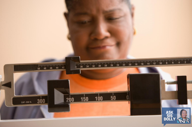 A woman weighing herself. 