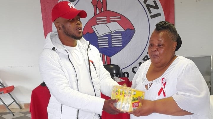 Gospel singer Khulekani Chilli presents his donation to the owner of Thola Ulwazi Home Base Care, Venile Lekhwane.