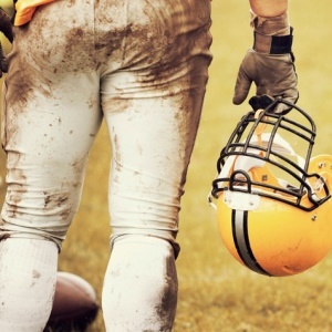 American football player with helmet – iStock