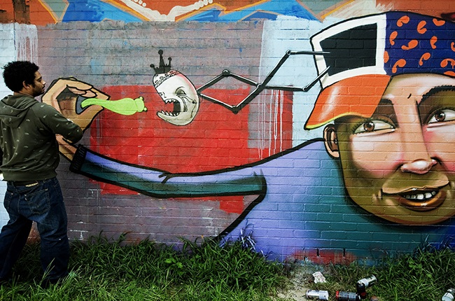 South African Graffiti artist Falko Starr finishes one of his artwork on 9 September 2010 on a wall in the Cape Flats suburbs on the outskirt of Cape Town, South Africa.