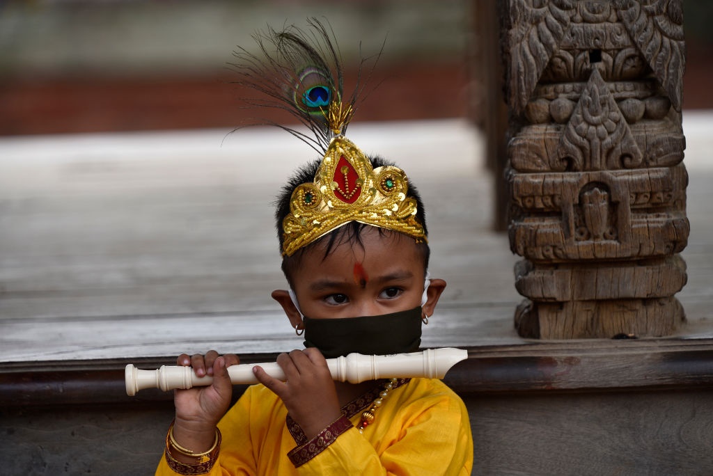A Kid dressed as the Hindu god Krishna along with 