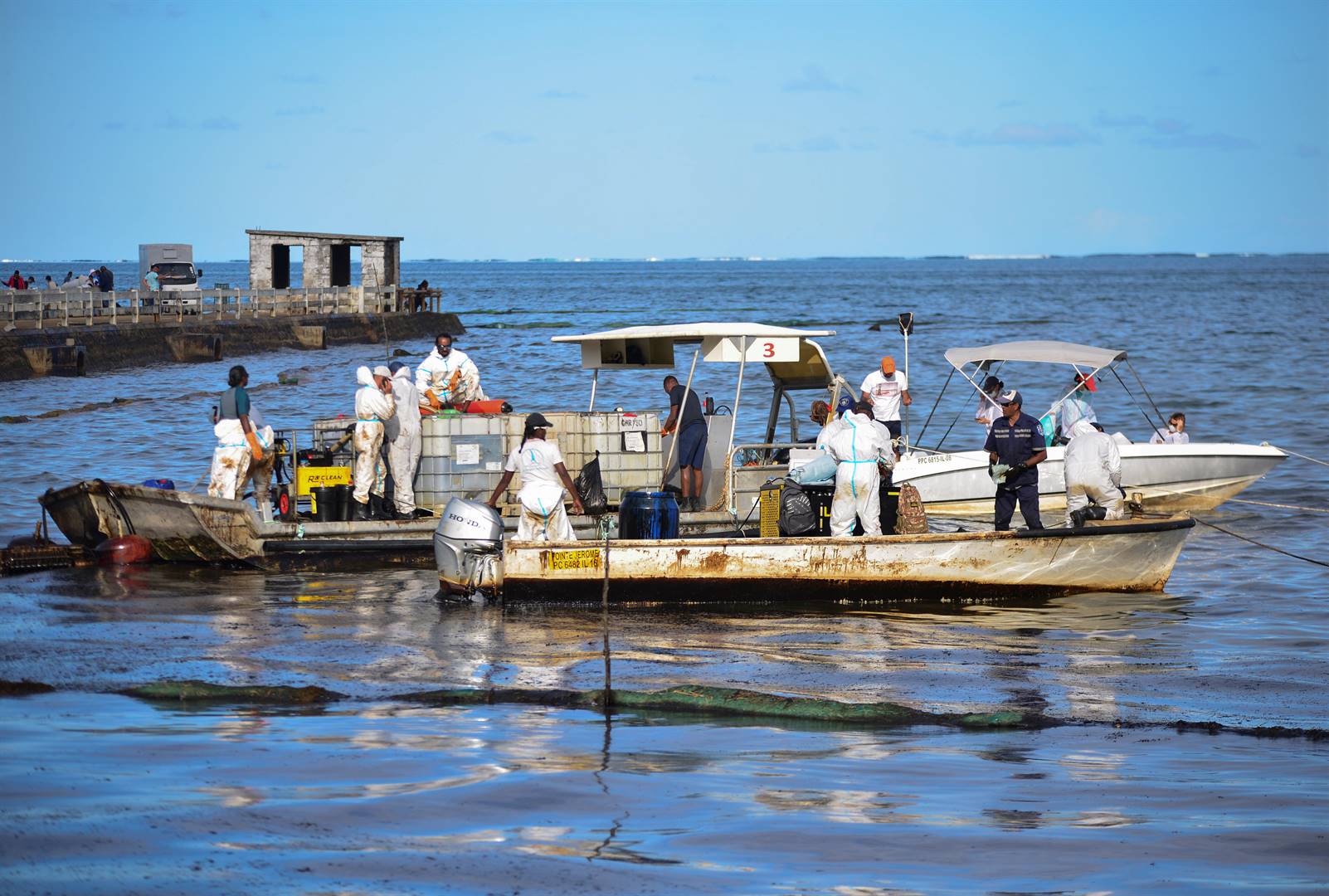 Vrywilligers help om olie wat uit die “Wakashio” gelek het, op te ruim.  Foto: Reuters
