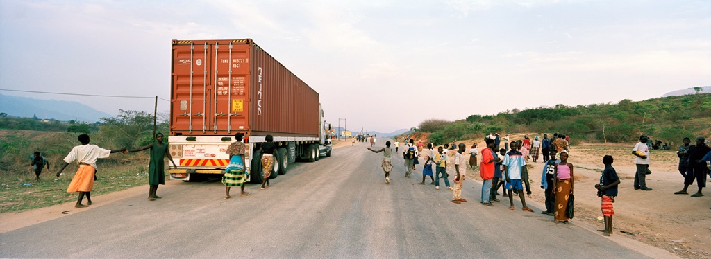 Various traders and money changers do their business as a truck leaves the border post at Machipanda to drive down the Beira Corridor, which links the port of Beira to Zimbabwe. Picture: Gideon Mendel/Corbis via Getty Images