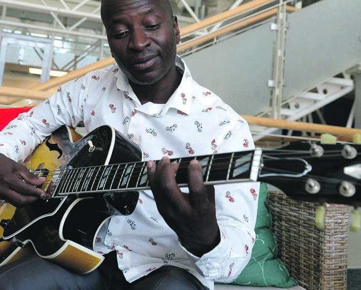 Legendary musician Selaelo Selota playing the guitar.
