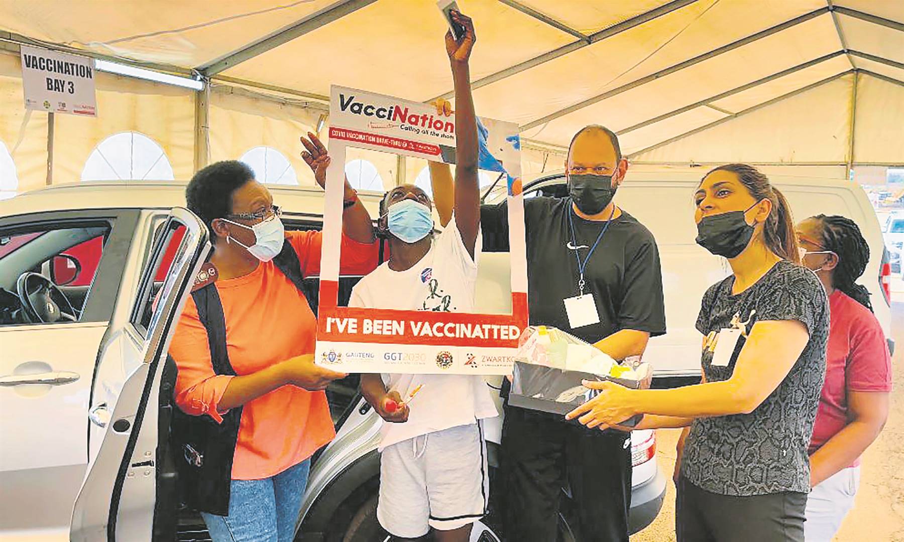 Teen Tadiwa Matetakufa (middle) became the 20 000th person to get his vaccination at the Zwartkops Drive Thru Vaccination Site in Centurion on Saturday. He was accompanied by his mum, Susan Njanji (left). 