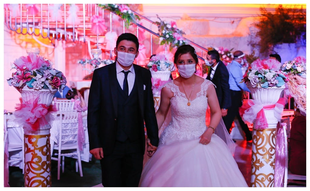 A bride and groom wearing medical masks as a precaution against coronavirus (Covid-19) during their wedding at Bornova district in Izmir, Turkey on July 1, 2020. Wedding halls in Izmir started to provide controlled services within the scope of new types of coronavirus measures. (Photo by Omer Evren Atalay/Anadolu Agency via Getty Images)