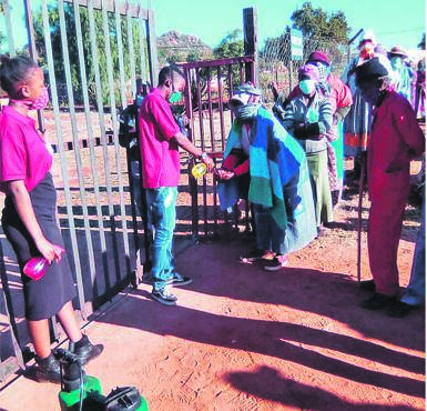 Paseka Makgalaborwa sanitises elders at a pay point in Burgersfort, Limpopo.