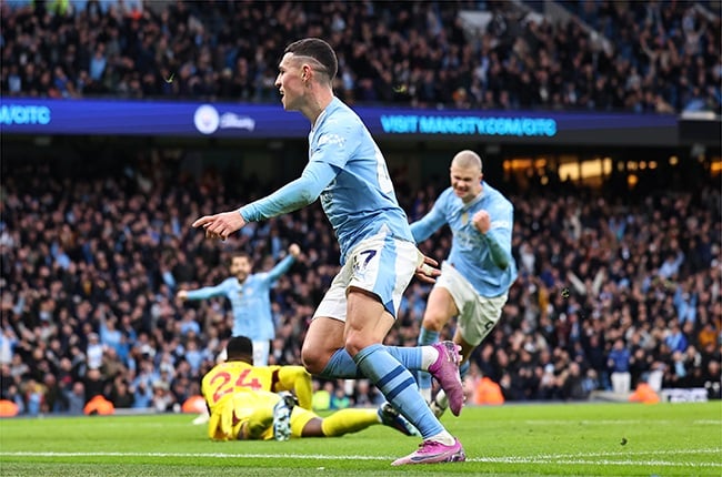 Manchester City forward Phil Foden wheels away after securing his brace against Manchester United at the Etihad Stadium on Sunday, (Image: Robbie Jay Barratt /AMA/Getty Images)