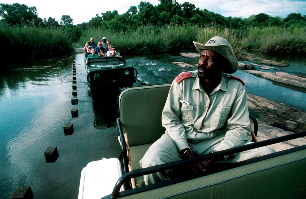 Tourists on safari ride in open Land Rovers September 13, 1997 at Mala Mala, an exclusive game lodge in Kruger Park, South Africa. South Africa has become a large tourist destination after the end of Apartheid in 1994. (Photo by Per-Anders Pettersson/Getty Images)