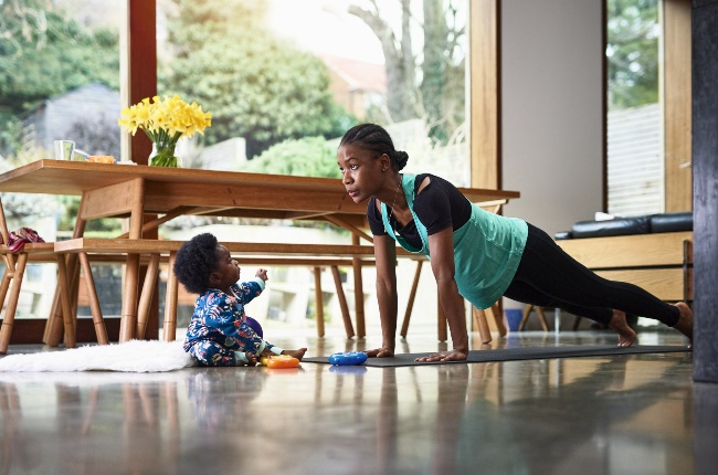 A woman and her child doing yoga in the kitchen