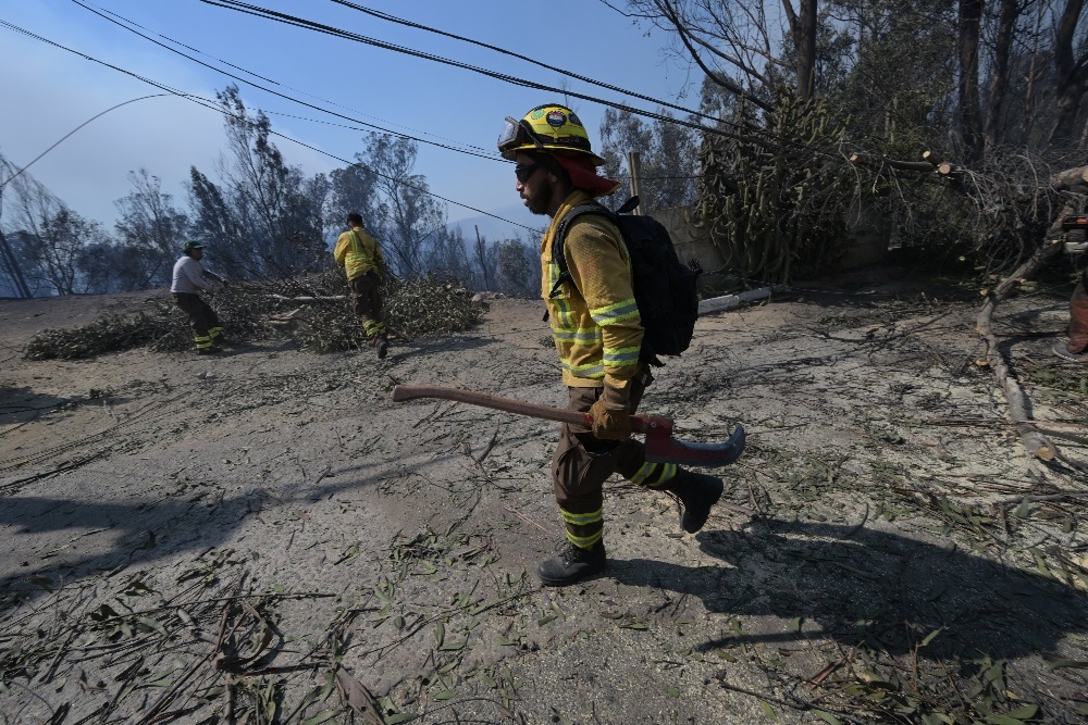 Firefighters work in the zone affected by a fire at the hills in Quilpue comune, Viña del Mar, Chile on 3 February 2024.