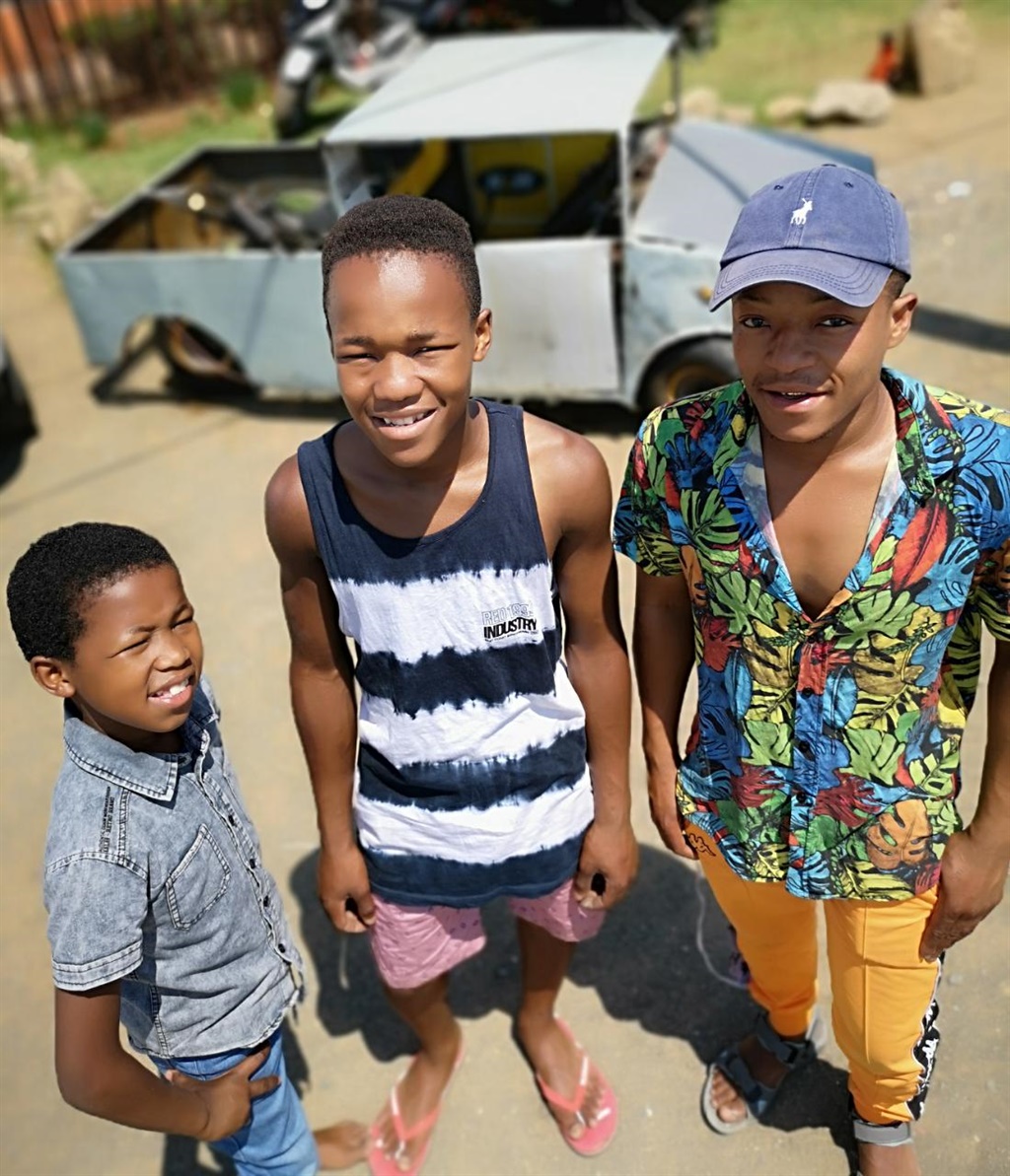 Obakeng's brothers, Ofentse (11) and Olebogeng (22) flank him in front of his new bakkie. Photo: Kabelo Tlhabanelo.