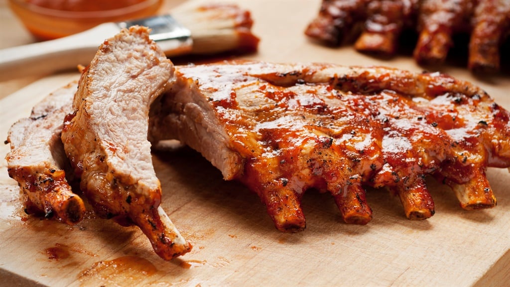 Ribs with sauce on a cutting board.